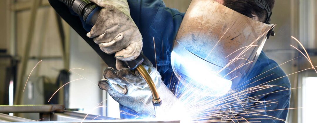 welder works in metal construction - construction and processing of steel components